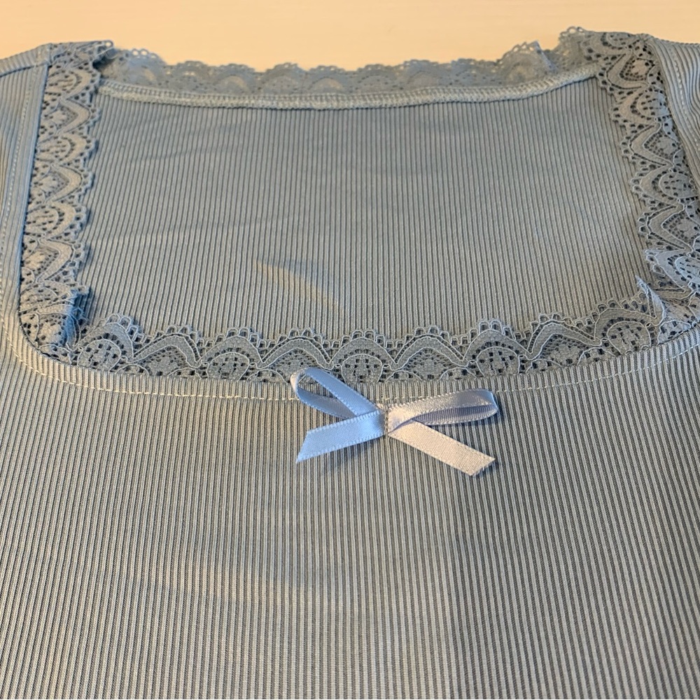 Long sleeve baby blue top with bow and lace. Brand new with tags.
